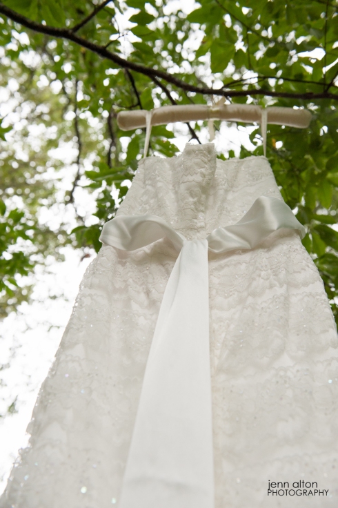Wedding gown details displayed in a green leafy tree. 