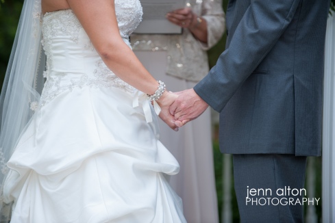 Bride and groom holding hands during ceremony, Pinehills Golf Club Ceremony