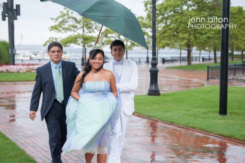 Quinceanera, father and Chambelan under umbrella at park, East Boston